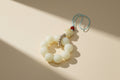 Beaded charm with a small figurine on a textured gray background