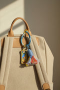 Colorful keychain with a blue figure on a beige background