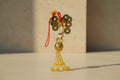 Decorative Chinese good luck charm with coins, beads, and a horse figure on a white background