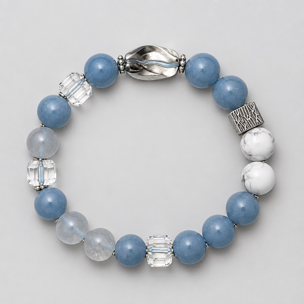 A beaded stretch bracelet featuring light blue and white beads, clear faceted crystal beads, and textured silver-toned spacer accents, displayed on a neutral gray textured background.
